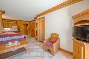 een woonkamer met een bank en een tv bij Résidence Le Cristal - Mont Blanc 5 - Happy Rentals in Chamonix-Mont-Blanc