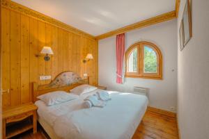 een slaapkamer met een groot wit bed en een raam bij Résidence Le Cristal - Mont Blanc 5 - Happy Rentals in Chamonix-Mont-Blanc
