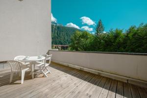 een patio met een tafel en stoelen op een balkon bij Résidence Le Cristal - Mont Blanc 5 - Happy Rentals in Chamonix-Mont-Blanc