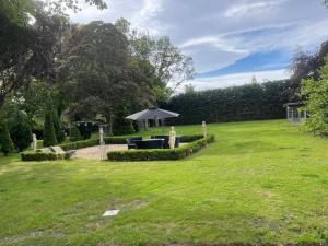 a garden with a table and an umbrella at Castle Gogar Cottage in Edinburgh