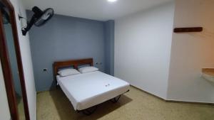 Un pequeño dormitorio con una cama blanca en una habitación en Hotel Medellin Kapital, en Medellín
