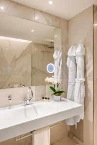 ein weißes Badezimmer mit einem Waschbecken und einem Spiegel in der Unterkunft Hotel The Square Milano Duomo - Preferred Hotels & Resorts in Mailand