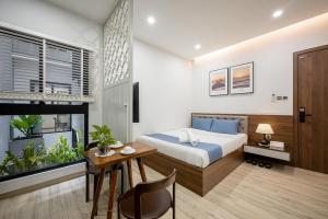 a bedroom with a bed and a desk and a table at Cozrum Homes - Kena House in Ho Chi Minh City