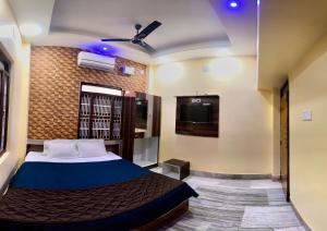 a bedroom with a bed and a flat screen tv at Bobby Premium Residency 350m from Jagannath temple in Puri