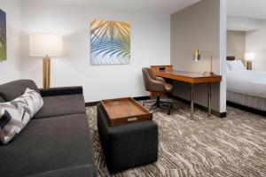 Una habitación de hotel con un sofá, un escritorio y una cama. en SpringHill Suites by Marriott Portland Hillsboro, en Hillsboro