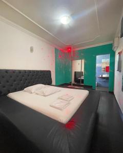 1 dormitorio con 1 cama con pintura roja en las paredes en 24 Horas Motel Jaguar Contagem en Contagem