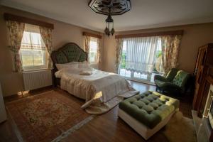 1 dormitorio con 1 cama, 1 silla y ventanas en Villa Greensea, en Büyükçekmece