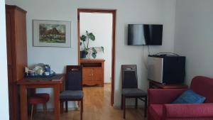 a living room with a table and a tv at Willa Tradycja in Łeba