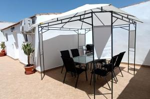 un tavolo e sedie sotto una tenda su un patio di Casa Torres - Traditional Village Experience a Cánovas