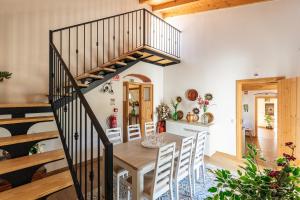 eine Küche und ein Esszimmer mit einem Holztisch und einer Treppe in der Unterkunft Villa Rodrigues in Boliqueime