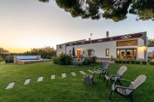 ein Haus mit zwei Stühlen und einem Pool in der Unterkunft Villa Rodrigues in Boliqueime