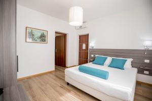 um quarto com uma grande cama branca com almofadas azuis em RESIDENCE VILLA TOTA em Spoleto