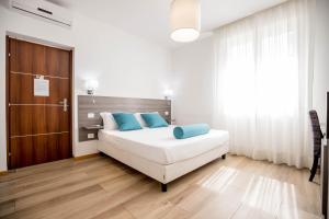 a bedroom with a large white bed with blue pillows at RESIDENCE VILLA TOTA in Spoleto