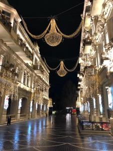 an empty street with christmas lights on the buildings at Nizami Street VIP Apartment in Baku