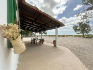 un patio con mesa y sillas bajo un techo en MASIA BLANCA, en Deltebre