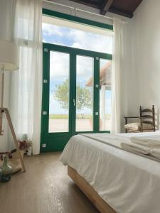 a bedroom with a bed and a large window at MASIA BLANCA in Deltebre