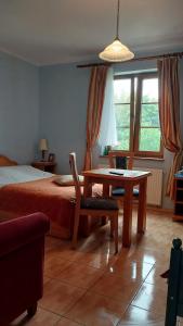 a bedroom with a bed and a desk and a table at Willa Tradycja in Łeba