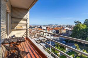 een balkon met een bank en uitzicht op de stad bij Casa da Praça in the center of Porto - GuestSPA in Porto