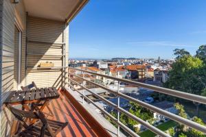 a balcony with a bench and a view of a city at Casa da Praça in the center of Porto - GuestSPA in Porto
