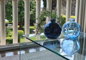 薩羅的住宿－Luxury Apartment right on the water Maddalena，玻璃桌边两只蓝色玻璃瓶