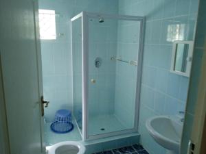 a bathroom with a shower with a sink and a toilet at Heberden chalets in Melville
