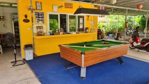 a pool table in front of a yellow wall at Lucky Home Prakhon Chai in Prakhon Chai