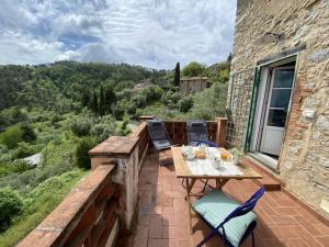a patio with a table and chairs on a balcony at Casa spaziosa in caratteristico paesino di alta collina in Santa Maria Albiano