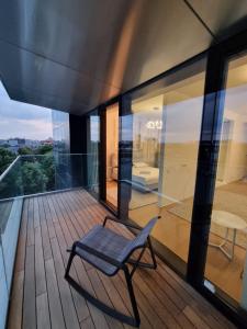 una silla sentada en el balcón de una casa en One Inclusive Best Region Apartment, en Bucarest