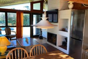 eine Küche und ein Wohnzimmer mit einem Kamin und einem Tisch in der Unterkunft Sommerhus, Hornbæk in Hornbæk