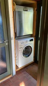 eine Waschmaschine mit einem TV darüber in der Unterkunft Sommerhus, Hornbæk in Hornbæk