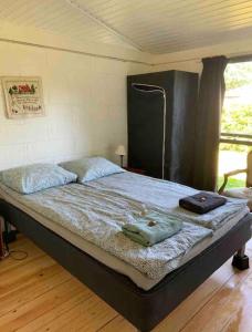 ein großes Bett in einem Zimmer mit in der Unterkunft Sommerhus, Hornbæk in Hornbæk