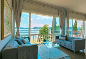 薩羅的住宿－Luxury Apartment right on the water Maddalena，客厅设有两张沙发和一个大窗户