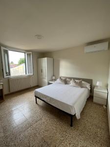 a bedroom with a large white bed and a window at Apartment Dalla Mirella in Florence