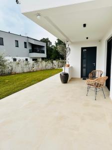een patio met een tafel en stoelen erop bij Villa Istra Relax Diamond in Rebići