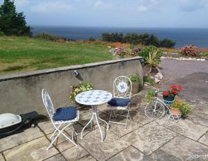 uma mesa e duas cadeiras e uma mesa e algumas flores em Teach Beag, Gortaforia, Kells, V23 N978 em Killarney