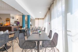 - une salle à manger avec des tables, des chaises et des fenêtres dans l'établissement Appart'City Classic Toulouse Colomiers, à Colomiers