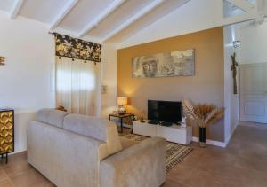 uma sala de estar com um sofá e uma televisão em Kajoane's villa em Sainte-Anne
