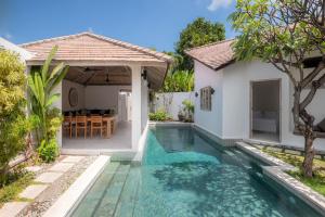 a villa with a swimming pool in front of a house at Villa Dipta in Seminyak