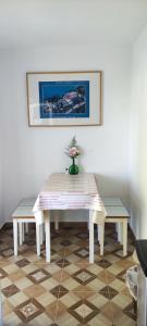 una mesa con dos bancos y un jarrón con flores. en Fecskefészek Nyaralóház, en Hajdúszoboszló
