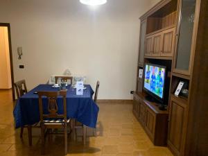 comedor con mesa azul y TV en Casa Donna Gilda by Holiday World, en San Cesario di Lecce