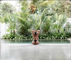 um vaso sentado no meio de uma piscina em Villa Oeste Modern Tropical 2BDR Villa Canggu em Munggu