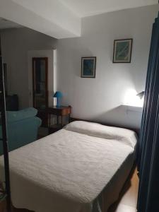 niewielka sypialnia z łóżkiem i krzesłem w obiekcie Studio St Jacques sur le chemin de pèlerinage w mieście Eymoutiers