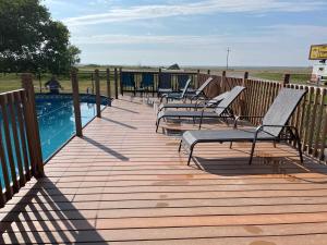 a deck with chairs next to a swimming pool at Badlands Hotel & Campground in Interior
