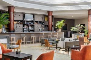 a lobby with a bar with chairs and tables at Paris Marriott Charles de Gaulle Airport Hotel in Roissy-en-France