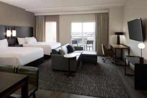 a hotel room with two beds and a couch at Residence Inn by Marriott Montreal Airport in Dorval +40 photos