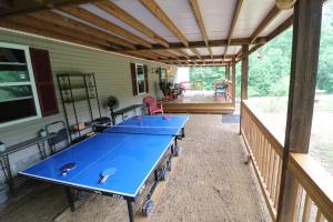 a screened porch with ping pong tables on it at Cozy Tennessee Plateau home with furnished outdoor living and 1G Wi-Fi in Crossville