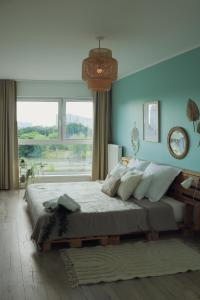 a bedroom with a large bed with a large window at Malta Lake - Apartment in Poznań