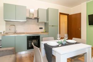 a kitchen with a table and a white table and chairs at Torino Comfy Apt - w/ Private Parking in Turin