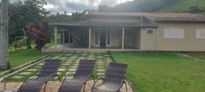 two chairs sitting in a yard in front of a house at Sitio Chacara temporada Lindoia Villa Vale in Lindóia