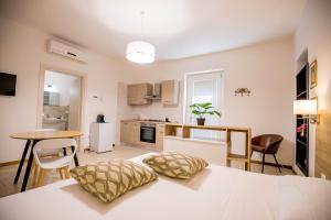 a bedroom with a white bed and a kitchen at RESIDENCE VILLA TOTA in Spoleto
